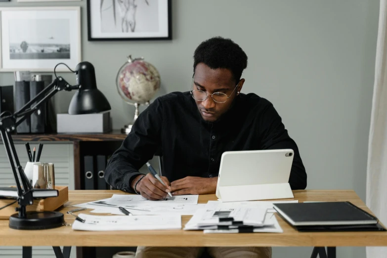 a man sitting at a desk working on a laptop, a drawing, by Carey Morris, pexels contest winner, jemal shabazz, writing on a clipboard, jayison devadas, post graduate