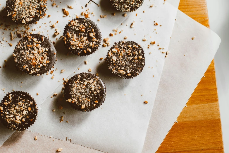 a bunch of cupcakes sitting on top of a table, by Daniel Lieske, pexels contest winner, hurufiyya, rocky roads, on a wooden desk, 🦩🪐🐞👩🏻🦳, detailed product image