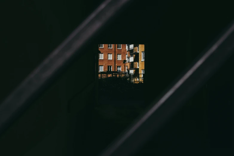 a window with a view of a building through it, inspired by Elsa Bleda, pexels contest winner, abstract illusionism, apartment with black walls, square shapes, metallic shutter, brick building