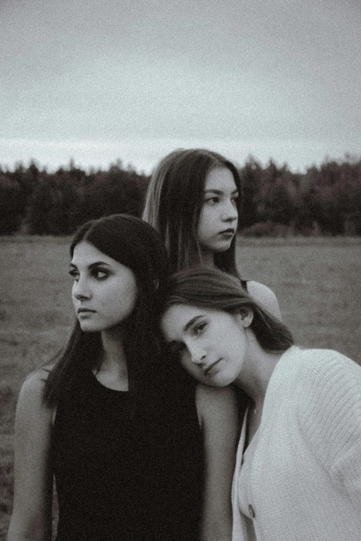 three women standing next to each other in a field, a black and white photo, unsplash, antipodeans, (beautiful) girl, 3 band lineup, teenager, beautiful fine - face