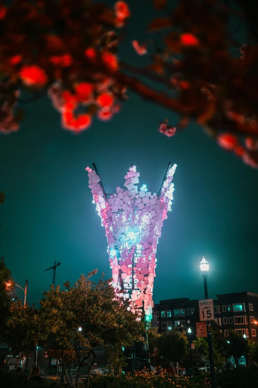 the fireworks is lit up in the night sky, interactive art, flowers growing out of its head, public art, resembling a crown, photograph taken in 2 0 2 0