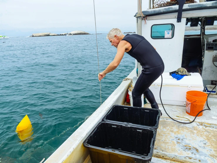 a man standing on top of a boat next to a yellow buoy, sea weed, digging, neuroscience, an oldman