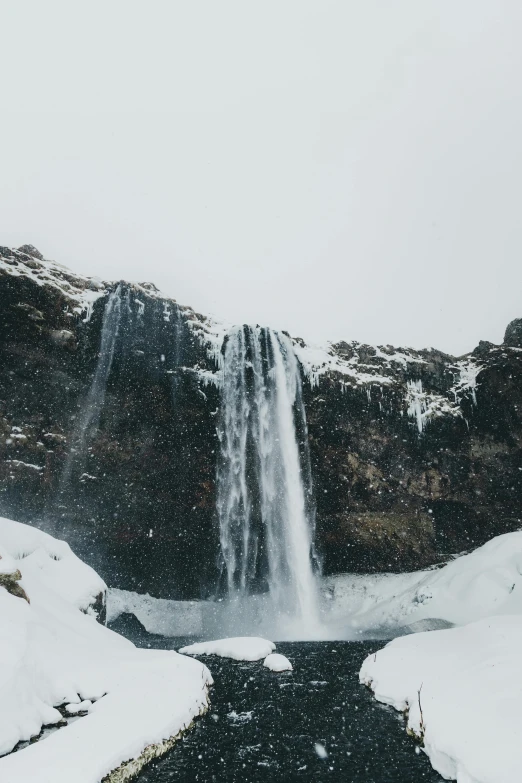 a waterfall in the middle of a snowy landscape, trending on unsplash, from of thrones, low quality photo, tourist photo, wide image