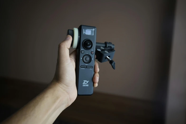 a person holding a remote control in their hand, inspired by Zhu Da, z brush, tilted camera angle, cruise control, professional product shot