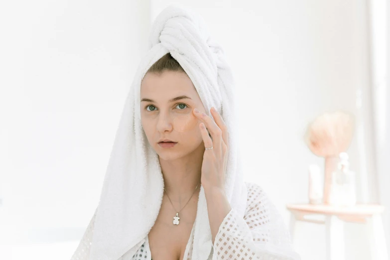 a woman with a towel wrapped around her head, by Emma Andijewska, trending on pexels, renaissance, hand on cheek, wearing a robe, beauty, during the day