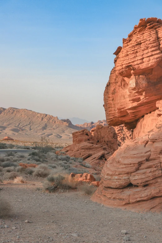 a large rock formation in the middle of a desert, las vegas strip, red sandstone natural sculptures, early morning light, seaside