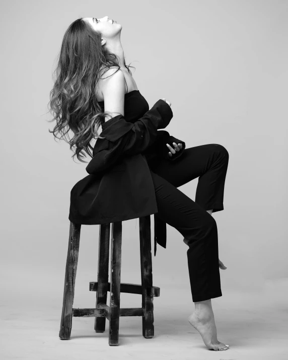 a woman sitting on top of a wooden stool, a black and white photo, unsplash, fine art, hailee steinfeld, wearing a black catsuit, alexey gurylev, profile picture