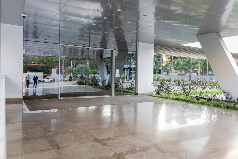 a view of a building through a glass door, by Hirosada II, unsplash, hyperrealism, avenida paulista, open shiny floor, empty buildings with vegetation, thumbnail