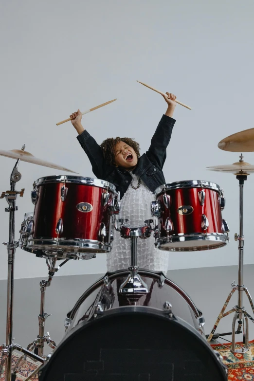 a woman that is standing in front of a drum set, excited, profile image, kid, onyx