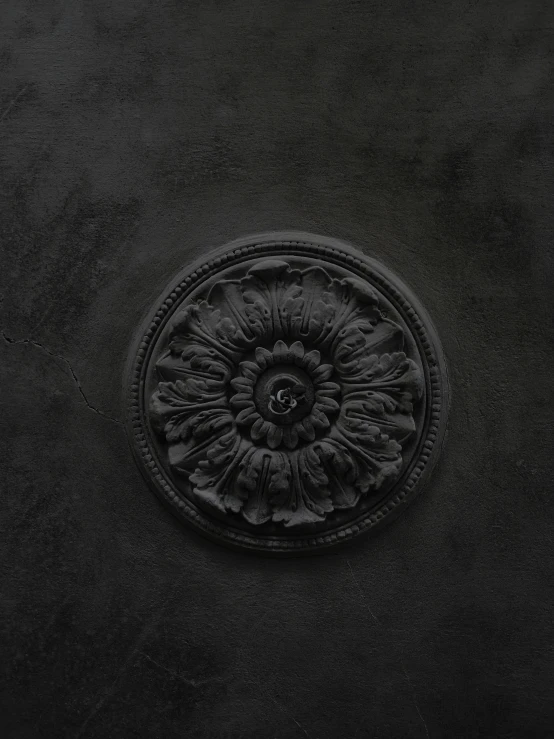 a black vase sitting on top of a table, an album cover, inspired by Antoine Verney-Carron, unsplash contest winner, baroque, detail texture, rosette, made of concrete, detailed product image