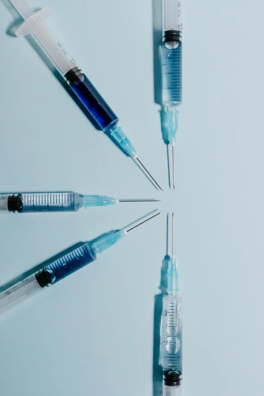 a group of sylls sitting next to each other, by Adam Marczyński, trending on pexels, conceptual art, syringes, blue colored, medical photography, small quills along it's back