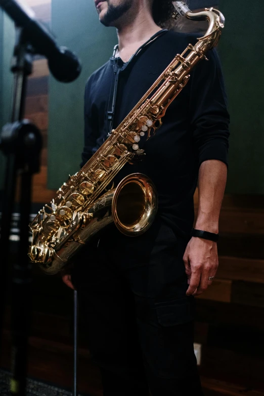 a man holding a saxophone in front of a microphone, trending on pexels, photorealism, australian, studio shot, 15081959 21121991 01012000 4k, kris kuksi