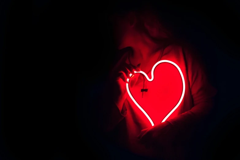 a person holding a red heart in the dark, by Adam Marczyński, pexels, bright neon signs, lesbians, ✨🕌🌙, profile image