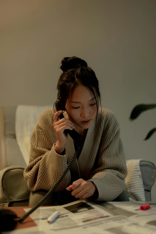 a woman sitting on a couch talking on a cell phone, by Kim Tschang Yeul, trending on pexels, hyperrealism, goodnight, 8 k movie still, late autumn, asian descent