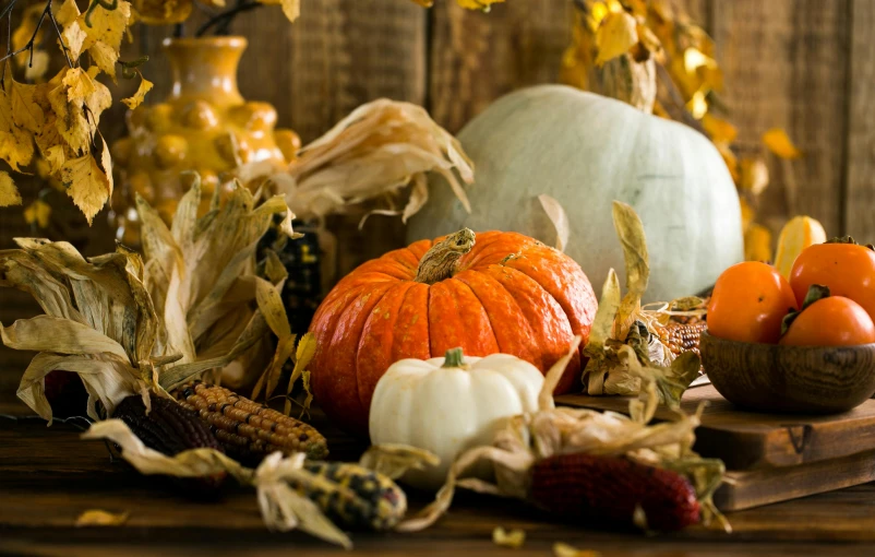 a bunch of pumpkins sitting on top of a wooden table, profile image