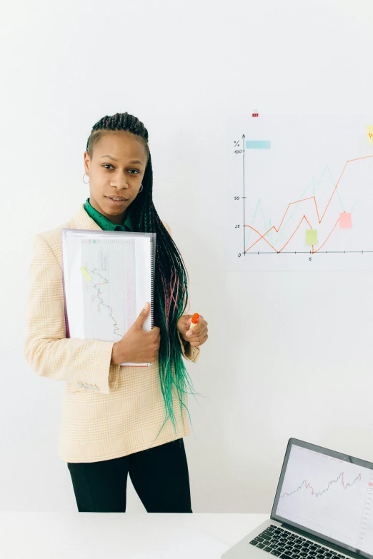 a woman standing in front of a laptop computer, trending on unsplash, analytical art, whiteboards, black woman, nonbinary model, graphs