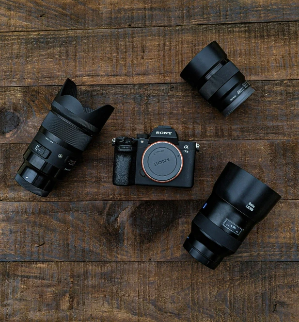 a couple of cameras sitting on top of a wooden table, by Sven Erixson, unsplash contest winner, zeiss lenses, high angle camera, shot with sony alpha 1 camera, stacked image