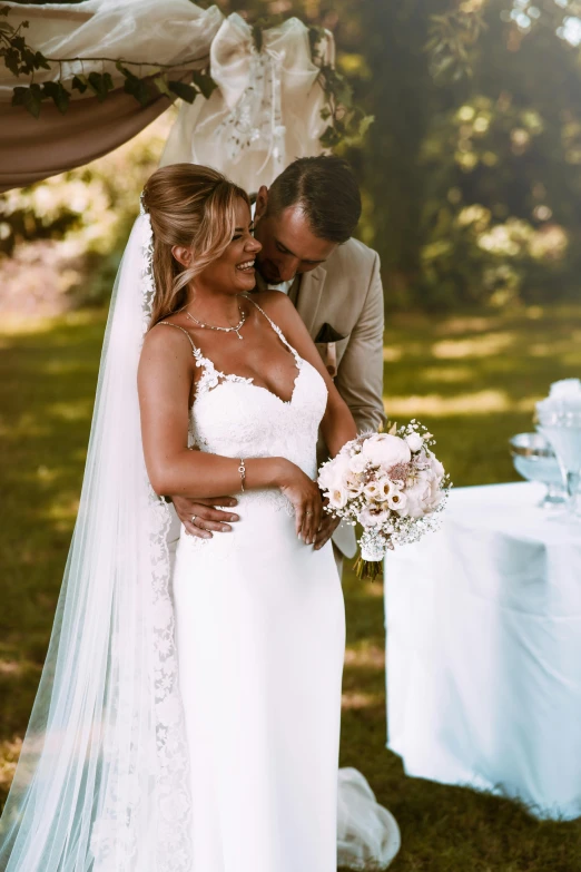 a man standing next to a woman in a wedding dress, in the sun, sublime-comfy-elegant ambience, bouquet, award winning image