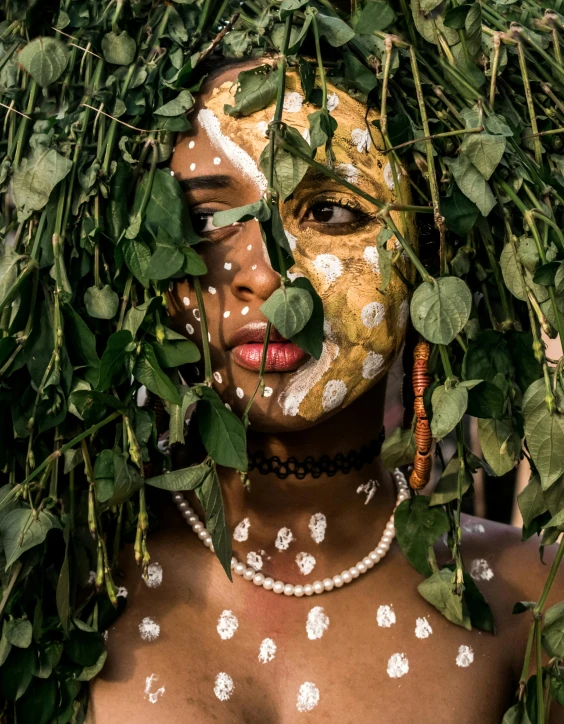 a close up of a person with leaves on their head, an album cover, inspired by Elsa Bleda, trending on unsplash, afrofuturism, white facepaint, wearing a dress made of vines, camouflage made of love, provocative indian