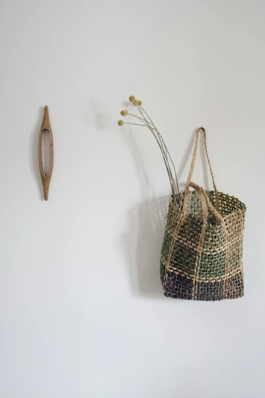 a close up of a bag hanging on a wall, by Jessie Algie, mingei, natural materials, curated collection, grid arrangement, walking to the right