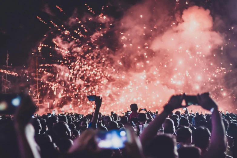 a crowd of people taking pictures of fireworks, pexels, photograph of three ravers, background image, numerous fires, revellers