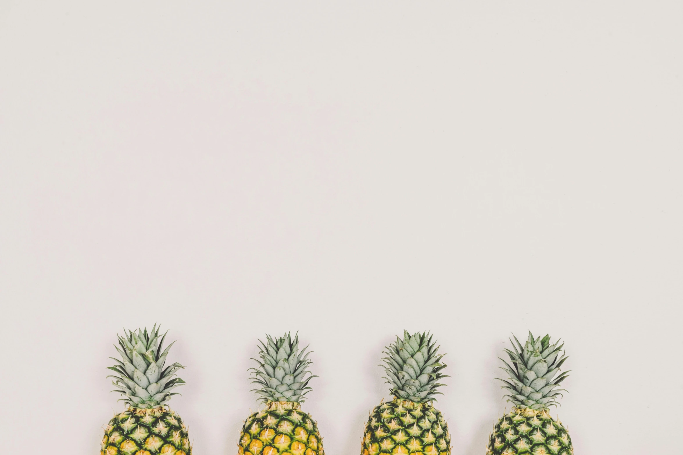 a row of pineapples on a white surface, by Adam Marczyński, trending on unsplash, minimalism, 🦩🪐🐞👩🏻🦳, portrait photo of a backdrop, perfectly tileable, background image