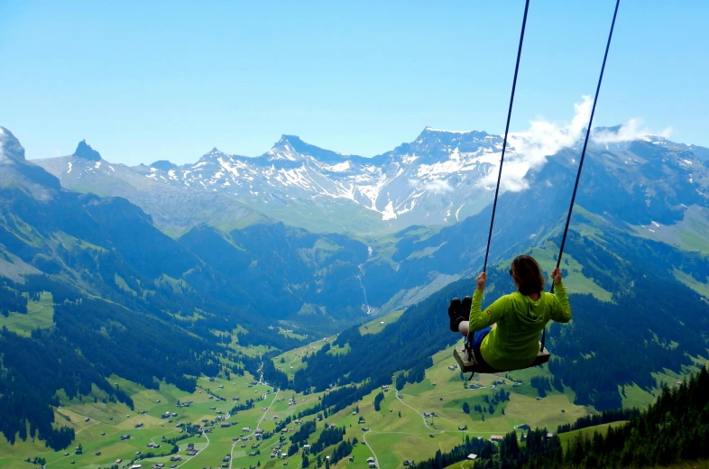 a person on a swing in the mountains, by Werner Andermatt, pexels contest winner, hurufiyya, suzanne engelberg, a green, avatar image