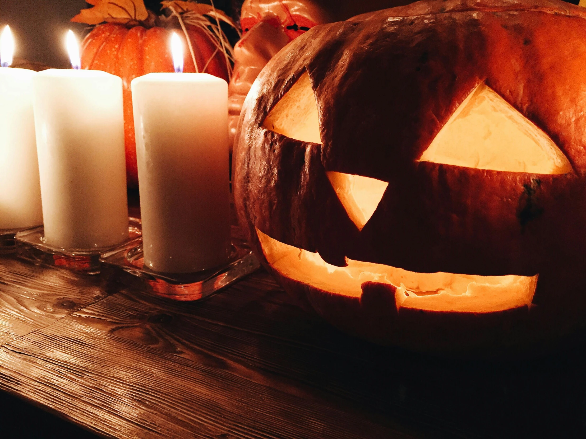 a pumpkin sitting on top of a table next to candles, pexels, vanitas, background image, profile pic, group photo, no watermarks