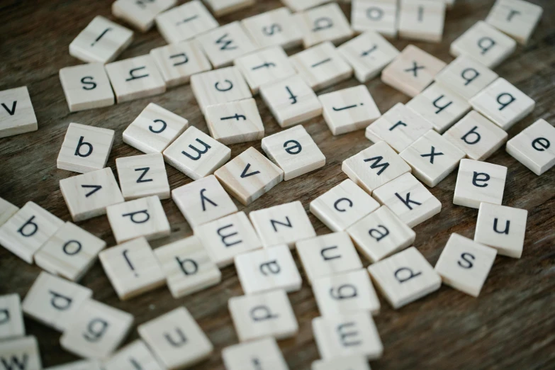 a pile of scrabbles sitting on top of a wooden table, by Emma Andijewska, unsplash, letterism, 15081959 21121991 01012000 4k, mosaic, ivory, thumbnail