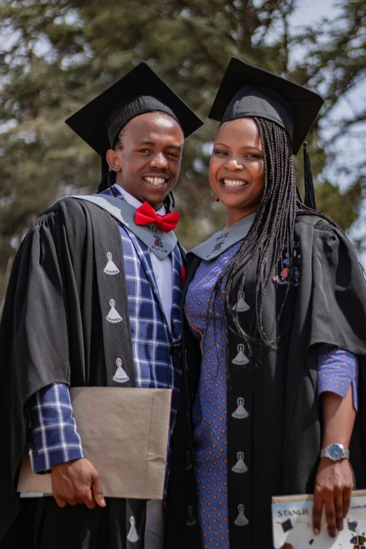 a couple of people standing next to each other, a portrait, unsplash, academic art, wearing an academic gown, mongezi ncaphayi, photograph taken in 2 0 2 0, celebrating