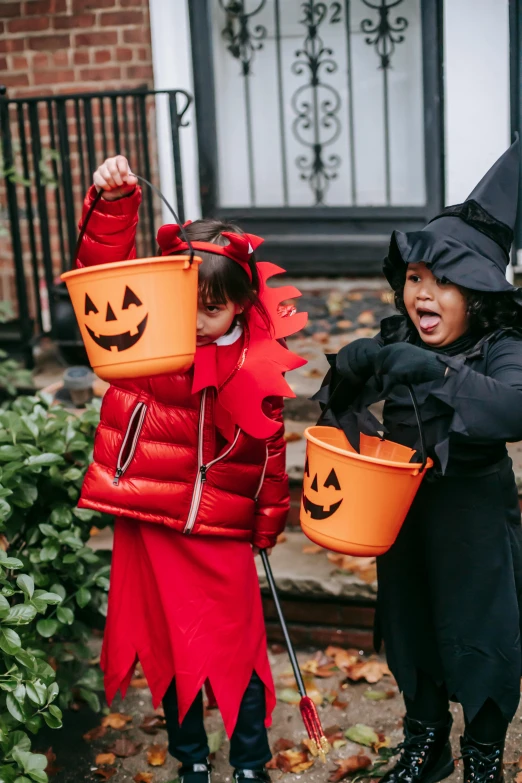 two children dressed in halloween costumes holding buckets, by Nina Hamnett, pexels, slate, gif, gemma chen, holy