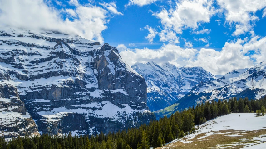 a group of people riding skis down a snow covered slope, a matte painting, by Daniel Seghers, pexels contest winner, les nabis, lauterbrunnen valley, avatar image, panorama, on a sunny day