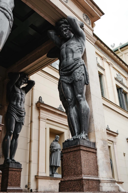 a couple of statues in front of a building, a statue, by Károly Markó the Elder, mannerism, extremely muscular, his arms and legs are hanging, archways between stalagtites, incredibly strong and tall