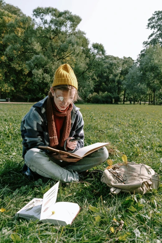 a person sitting in the grass reading a book, trending on pexels, visual art, beanie, portrait of a female art student, korean artist, chemistry