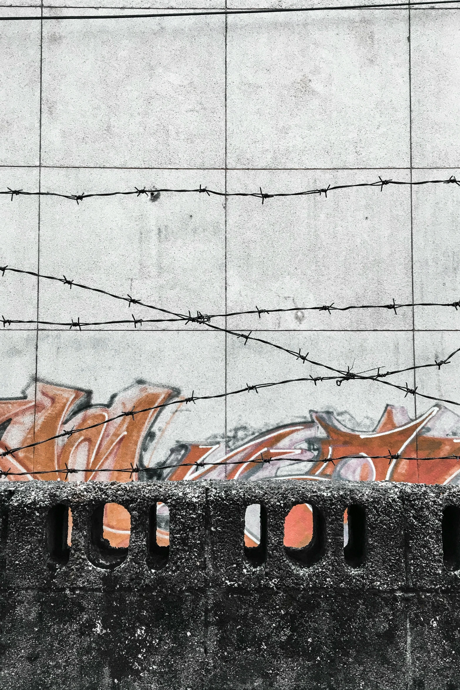 a red fire hydrant sitting on top of a cement wall, an album cover, unsplash, graffiti, tracks of barbed wire, wall mural, made of wire, ilustration