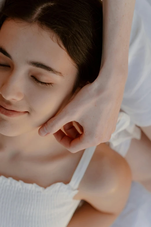 a woman laying on a bed with her eyes closed, hands shielding face, soft round features, neck zoomed in, holding an epée