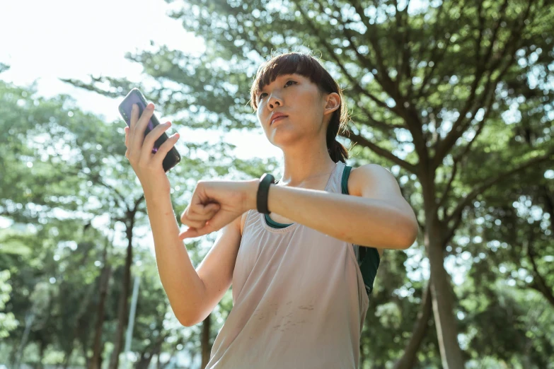 a woman holding a smart phone in a park, pexels, realism, working out, square, chinese, 1450