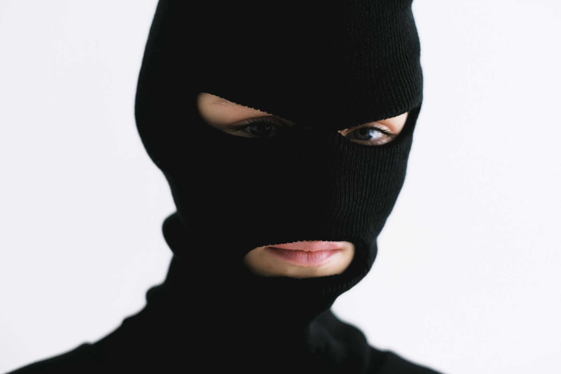 a close up of a person wearing a black mask, an album cover, by Nina Hamnett, bank robbery, wearing turtleneck, photographed for reuters, album cover