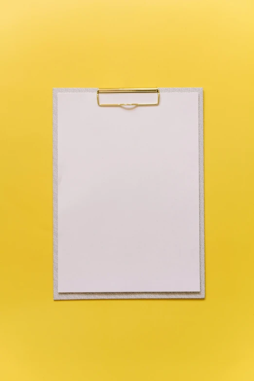 a white clipboard on a yellow background, unsplash, grey, low quality photo, matte background, no text