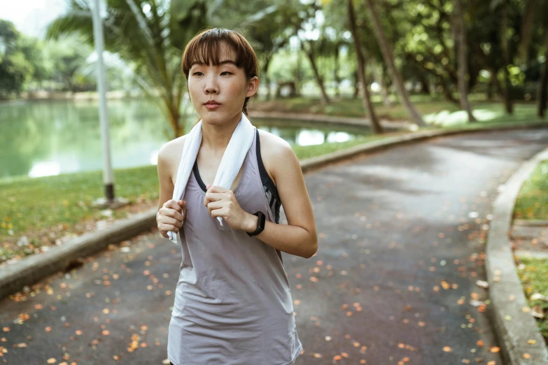 a woman running in a park with a towel around her neck, a portrait, inspired by Ruth Jên, pexels contest winner, half asian, hydration, avatar image, blank