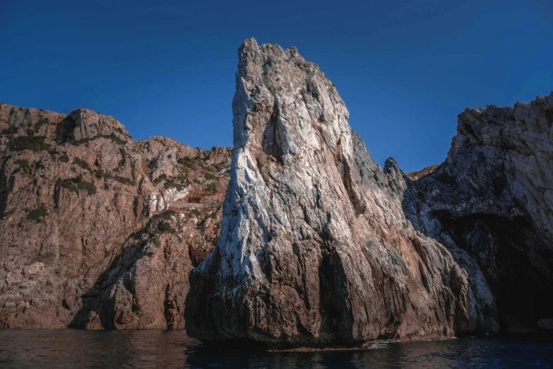 a large rock in the middle of a body of water, steep cliffs, piroca, fan favorite, ((monolith))