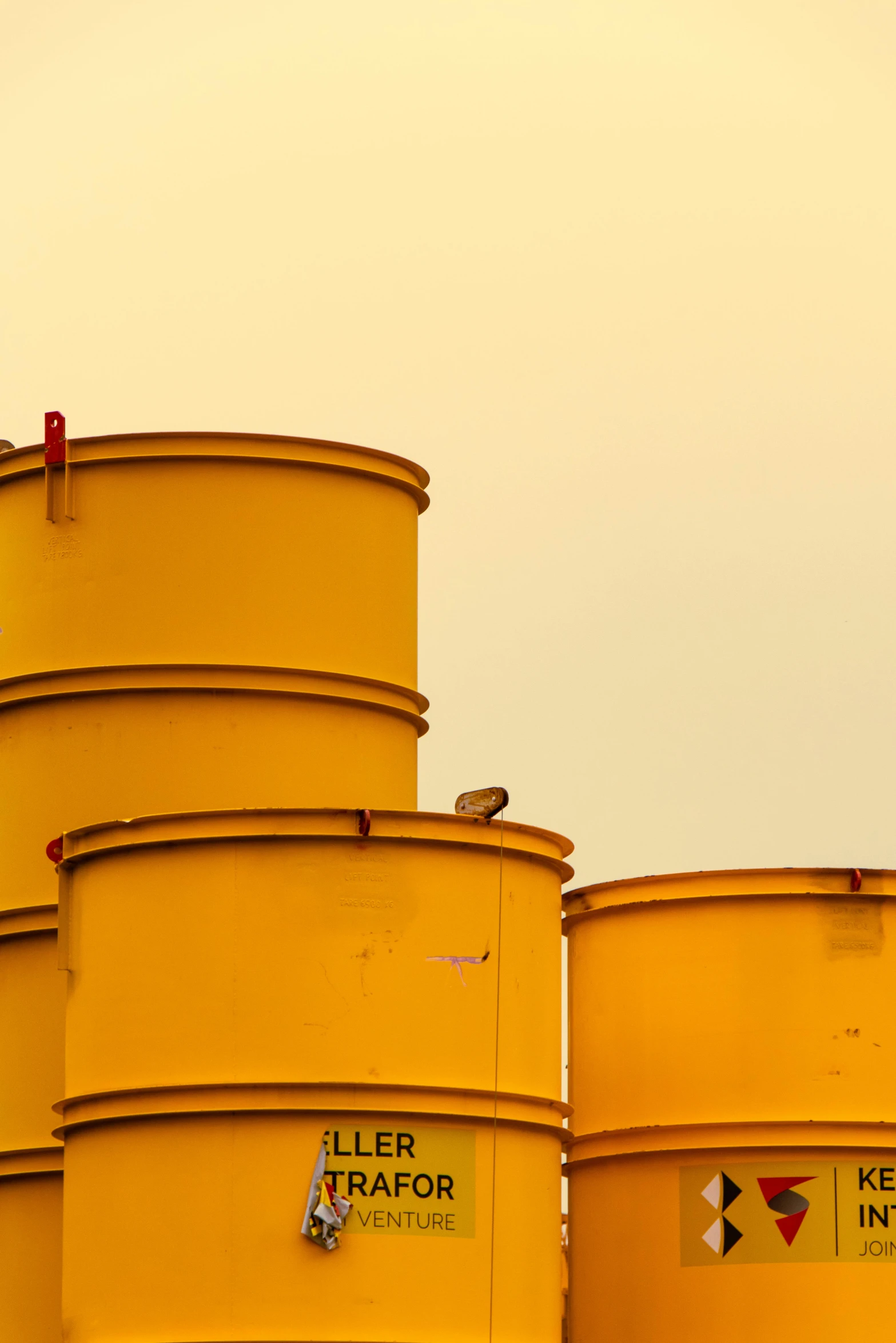 a group of yellow barrels sitting next to each other, a photo, by Sven Erixson, postminimalism, oil rig, flat curves, morning detail, colors: yellow