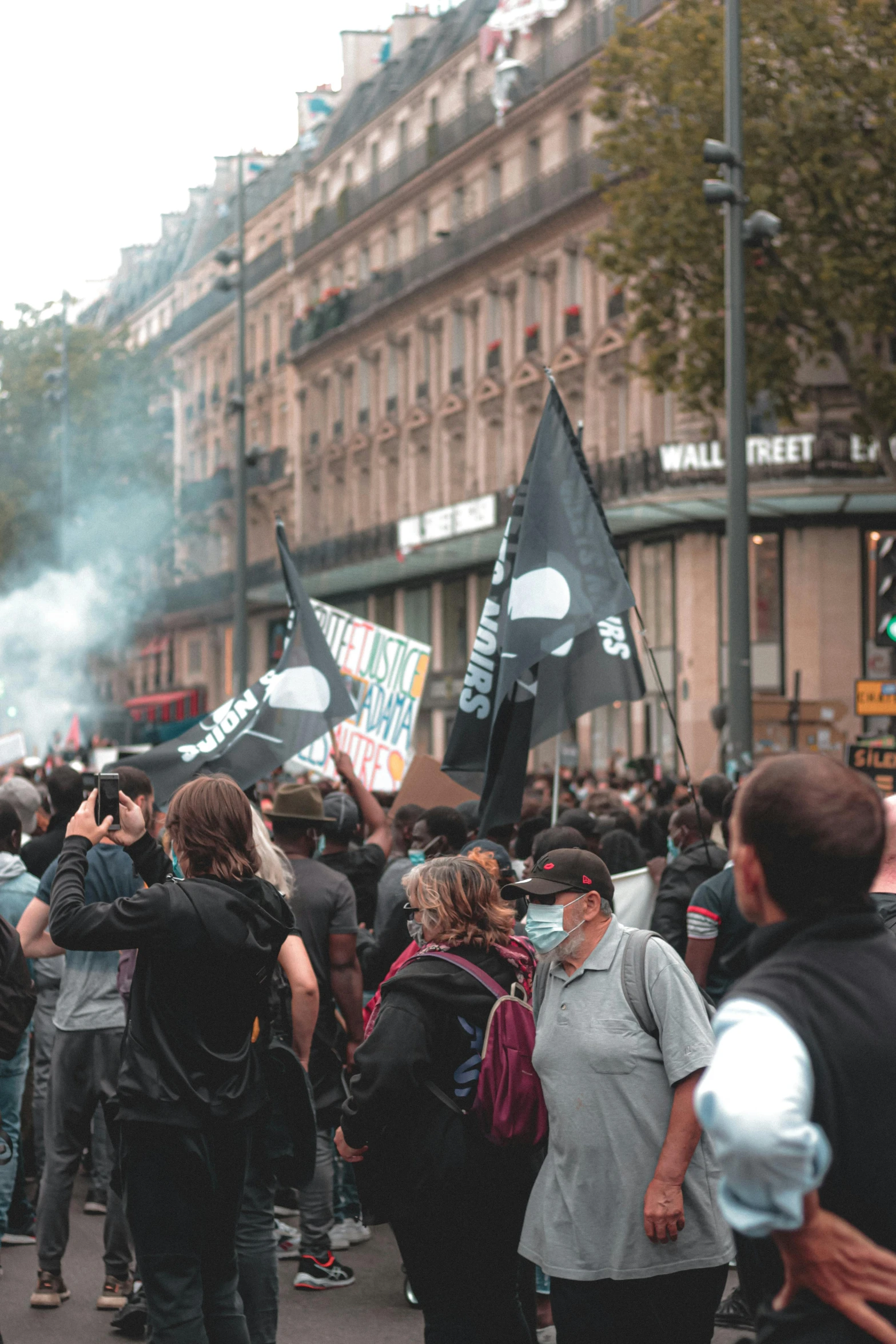 a group of people that are standing in the street, tear gas and smoke, in paris, profile pic, banners