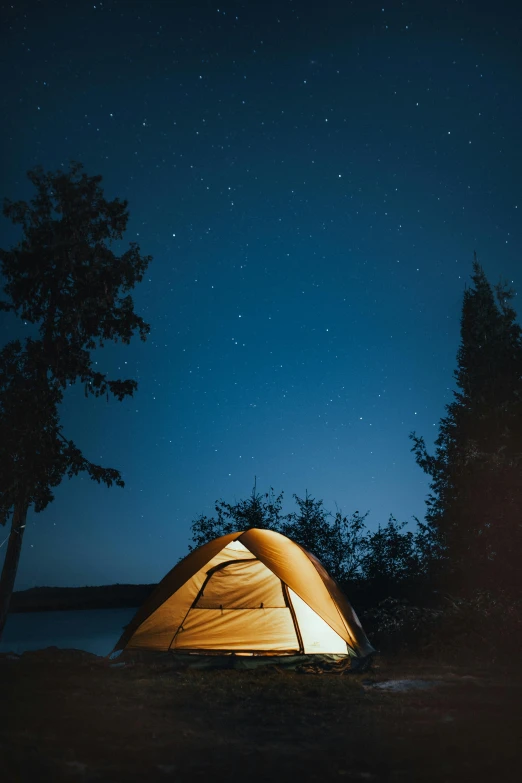 a yellow tent sitting on top of a lush green field, during the night, on a lake, paul barson, adventure gear