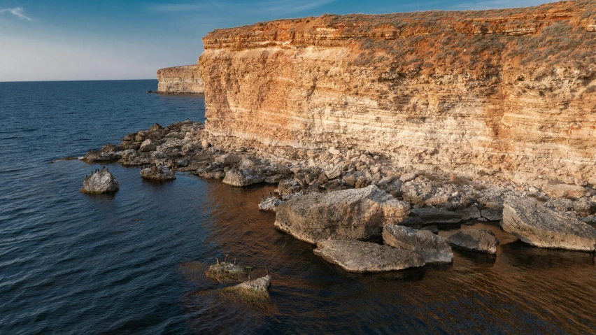 a cliff on the edge of a body of water, by Simon Marmion, pexels contest winner, les nabis, sandstone, widescreen, byzantine, listing image