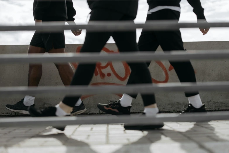 a group of people walking down a sidewalk next to the ocean, trending on unsplash, graffiti, detailed legs looming over you, cell bars, school class, amr elshamy