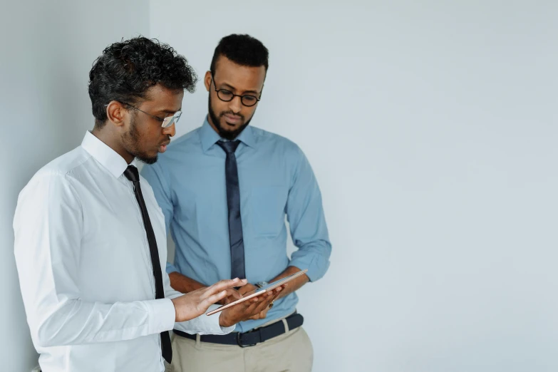 a couple of men standing next to each other, pexels, hurufiyya, integrating with technology, teaching, ( ( dark skin ) ), wearing business casual dress