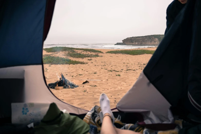 a person laying in a tent on a beach, pexels contest winner, portugal, view out of a window, male and female, campsites