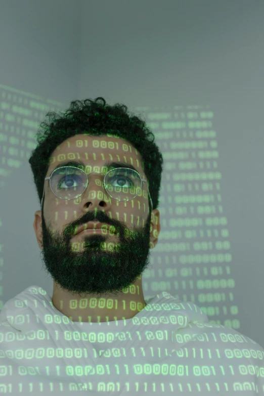 a man with a beard and glasses standing in front of a computer screen, pexels, holography, green matrix code, arab man light beard, taken in the early 2020s, a python programmer's despair