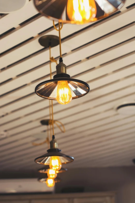 a bunch of lights hanging from the ceiling, pexels, light and space, warm lighting interior, cafe lighting, crisp lines, retro vibe